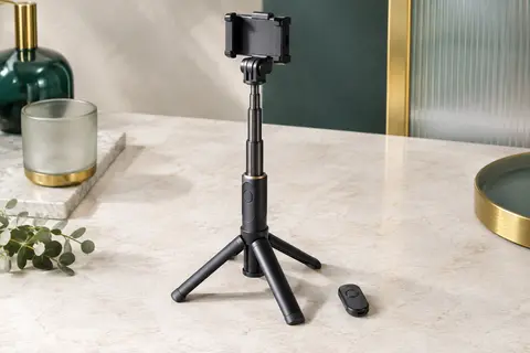 Perche trépied smartphone noire Anxre NT79 déployée sur une surface minérale claire, avec sa télécommande.
