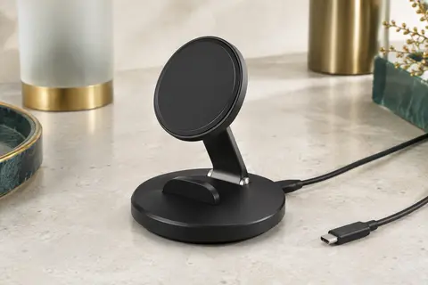 Socle de recharge magnétique noir avec support intégré et câble USB-C sur une surface claire.