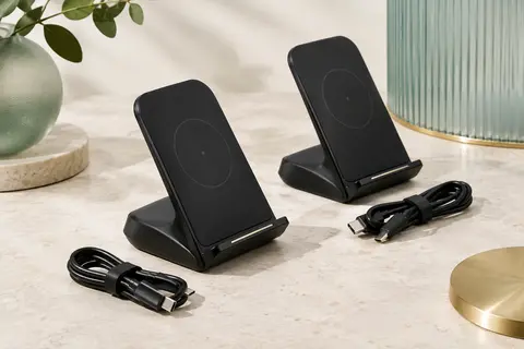 Deux supports noirs de recharge sans fil avec leurs câbles USB-C posés sur une surface claire